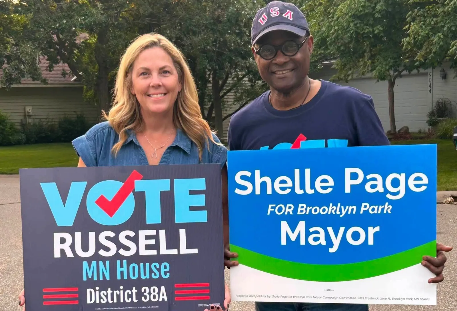 Wynfred Russell and Brooklyn Park mayoral candidate Shelle Page holding each other's campaign signs