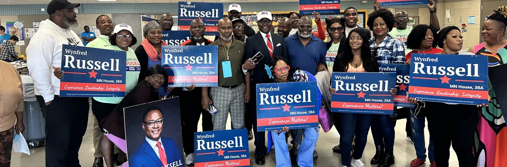 Volunteers and neighbours gathered with Wynfred Russell campaign signs